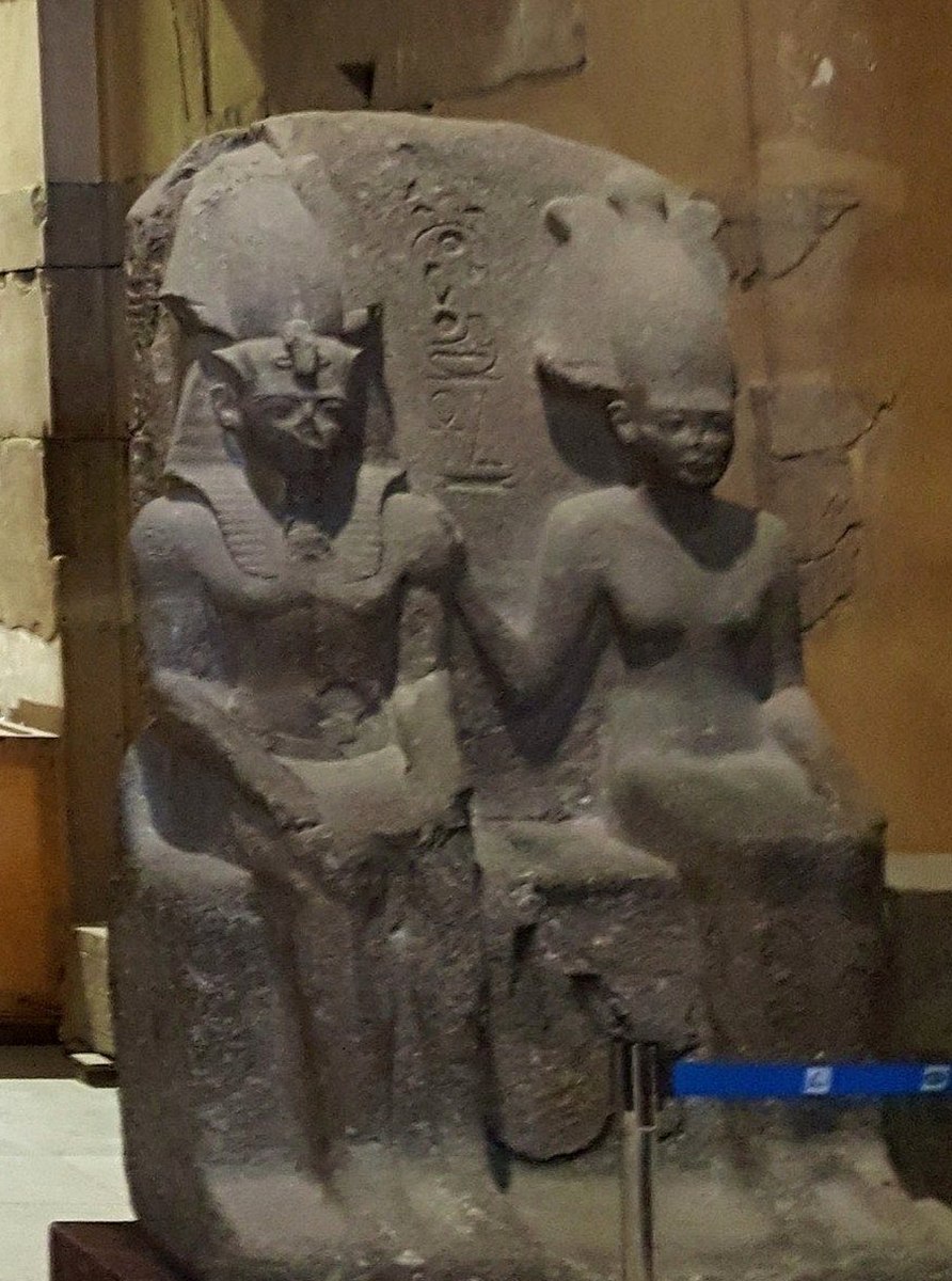 Visitors walking through a modern museum gallery with ancient Egyptian artifacts